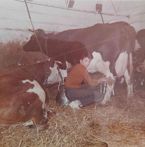 Marie à la ferme en train de traire une vache